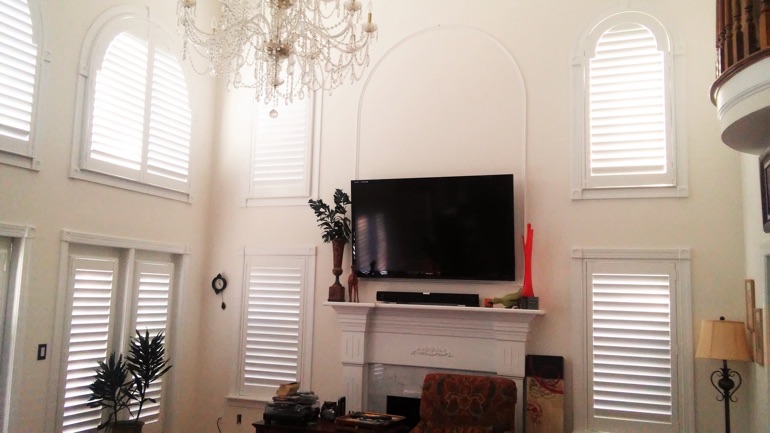 Bluff City great room with wall-mounted television and arched windows.